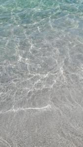 a close up of the water on a beach at La Difisola in Lizzano