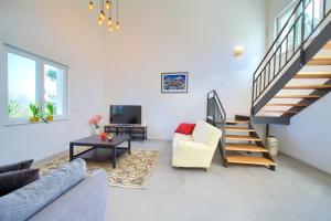 a living room with a staircase and a couch and a table at Villa Olivia in Vrh