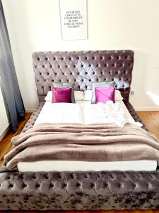 - une chambre avec un grand lit et des oreillers roses dans l'établissement Appartements-Dalila, à Sankt Michael im Lungau
