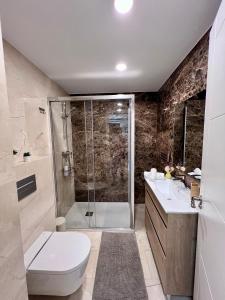 a bathroom with a shower and a toilet and a sink at Apartamentos Prestige Málaga Suites IV in Málaga