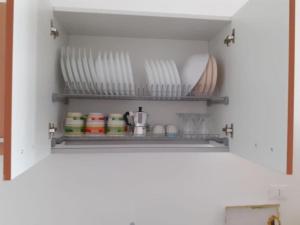 una despensa con platos y cuencos en un estante en La Difisola en Lizzano