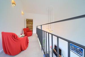 two red chairs sitting on a staircase in a house at Villa Olivia in Vrh +29 photos