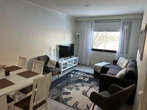 ein Wohnzimmer mit einem Sofa und einem Tisch mit Stühlen in der Unterkunft 2BR with sauna in Tornio city in Tornio