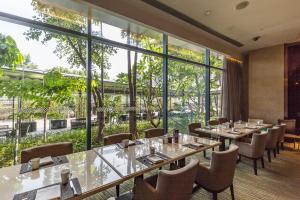 a restaurant with tables and chairs and large windows at Four Points by Sheraton Guangzhou, Dongpu in Guangzhou
