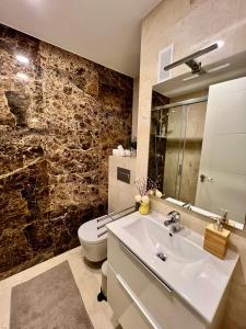 a bathroom with a white sink and a toilet at Apartamentos Prestige Málaga Suites IV in Málaga