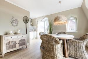 uma sala de jantar com uma mesa e cadeiras de vime em Hopfengarten, Whg 13, Beach Süster em Westerland