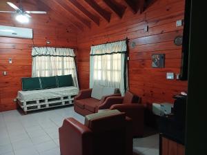 a living room with a couch and chairs in a cabin at Cabaña/ Quincho San Ciro in Formosa