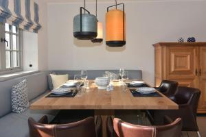 a dining room with a wooden table and leather chairs at Hüs bi See in Rantum