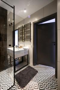 bagno con lavandino, doccia e specchio di Praga Zupnicza P&O Serviced Apartments a Varsavia