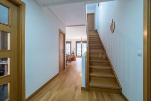 a staircase in a house with white walls and wooden floors at Casa Nea, tu hogar en La Rioja in Nalda