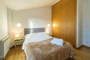 a bedroom with a large bed and a wooden cabinet at Casa Nea, tu hogar en La Rioja in Nalda