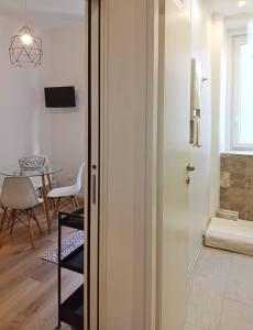 Cette chambre dispose d'une porte en verre et d'une table avec une chaise. dans l'établissement Tesa2 Casa Vacanze, à Trieste