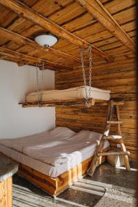 a bed in a wooden room with a ladder at Bedouin Forest Residence in Valevtsi