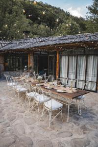 a long wooden table and chairs in front of a building at Bedouin Forest Residence in Valevtsi