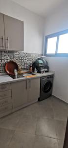 een keuken met een wastafel en een wasmachine bij اقامة مفتاح الساحل in Agadir