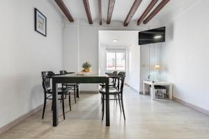 a dining room with a black table and chairs at Bettatur Apartaments Rera Sant Domenech in Tarragona