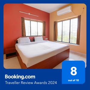 a bedroom with a large bed with orange walls at FabHotel Amar Raj Inn in Kolkata