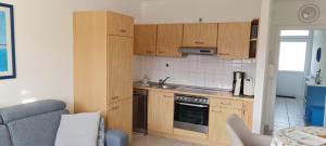 a small kitchen with wooden cabinets and a sink at Iderhoff Iderhoff 45 in Norderney +3 photos