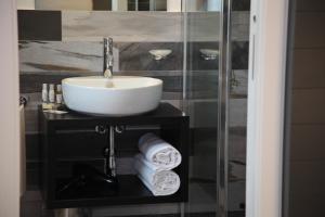a bathroom with a sink and a glass shower at Residenza RoMa in Tropea