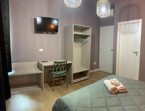 een slaapkamer met een bed, een bureau en een televisie bij LAME 46 ROOMS in Bologna