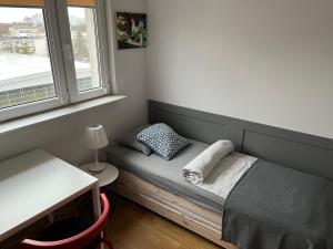 Cama pequeña en habitación con ventana en Apartament Słodowiec, en Varsovia