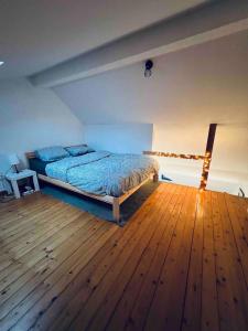 a bedroom with a bed and a wooden floor at Appartement net buiten stadskern in Hasselt