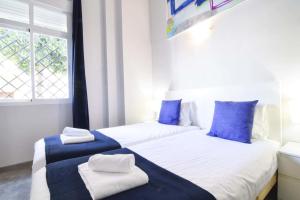 two beds in a room with blue and white at ENJOY CAPUCHINOS in Málaga