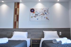 two beds in a room with a picture on the wall at SKYLINE Fine Living in Nei Poroi