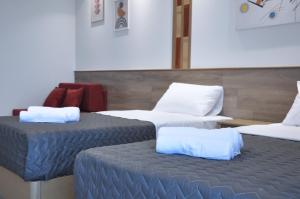 a room with two beds and a couch at SKYLINE Fine Living in Nei Poroi