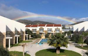 un arco iris sobre una casa con piscina en Villa View- Grapevines Villas - your sea view vacation, en Makrí Gialós