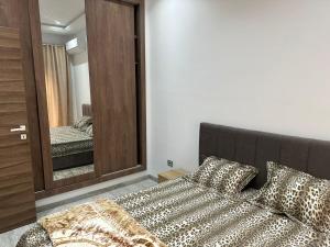 a bedroom with a bed and a large mirror at Studio ain Zaghouan nord la marsa استديو عين زغوان الشمالية المرسى in Tunis