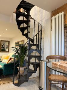 a black spiral staircase in a room with a bed at The Forge in Towcester