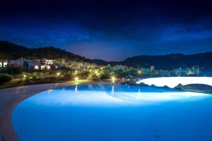 una piscina por la noche con una ciudad de fondo en Case Li Conchi F, en Castiadas