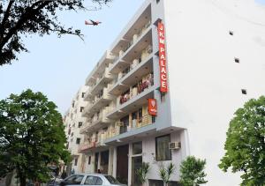 an airplane is flying over a building with cars at HOTEL JKM PALACE Near Apollo Hospital in New Delhi