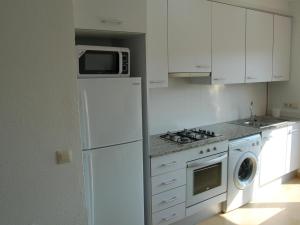 een keuken met een witte koelkast en een magnetron bij Apartamento Llançà, 2 dormitorios, 6 personas - ES-228-33 in Llança