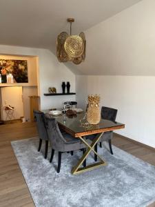 a dining room table with black chairs and a chandelier at Downtown No.2 in Bad Soden-Salmünster