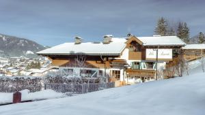 a house on a snow covered hill with at Villa Agricola in Kaprun