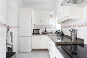 una cucina bianca con lavandino e frigorifero di Home2Book Cozy Apt La Marina, Santa Cruz Center a Santa Cruz de Tenerife