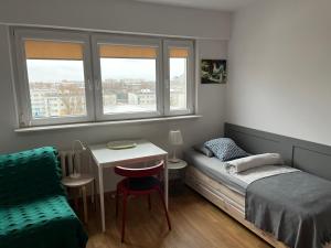 1 dormitorio con 1 cama, 1 mesa y 1 silla en Apartament Słodowiec, en Varsovia