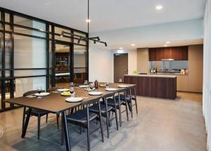 a dining room with a table and chairs and a kitchen at Luxe Apartment in Belconnen