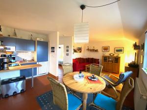 eine Küche und ein Wohnzimmer mit einem Tisch und Stühlen in der Unterkunft Gemütliches Apartment in Strandnähe in Dranske