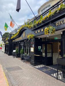 a building on a street with tables and chairs at International Hotel Killarney in Killarney
