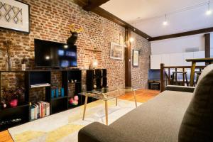 a living room with a brick wall and a glass table at Atypical apartment in the heart of Old Lille! in Lille