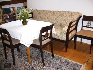 une table, des chaises et un canapé avec une table et des fleurs dans l'établissement Übernachten in der Kaiserpfalz, à Ingelheim-sur-le-Rhin