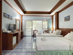 ein Hotelzimmer mit 2 Betten und einem TV in der Unterkunft Sea View Resort Rayong in Rayong