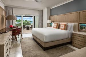 a bedroom with a large bed and a dining room at The Ritz-Carlton St. Thomas in Benner
