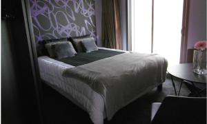 a bedroom with a bed with a purple wall at T2 La vue panoramique sur l'océan à 180 in Saint-Jean-de-Monts