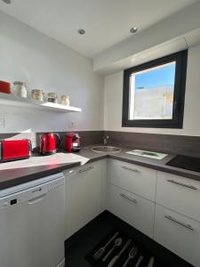 eine Küche mit weißen Schränken und einem Fenster in der Unterkunft T2 La vue panoramique sur l'océan à 180 in Saint-Jean-de-Monts