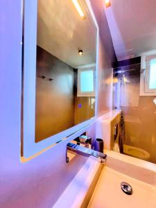 a bathroom with a large mirror above a sink at Elements - Air & Water Apartment by Hostandros in Gavrio +25 photos