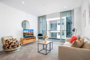墨尔本Retro Modern with Pool near Westfield Doncaster的带沙发和电视的客厅